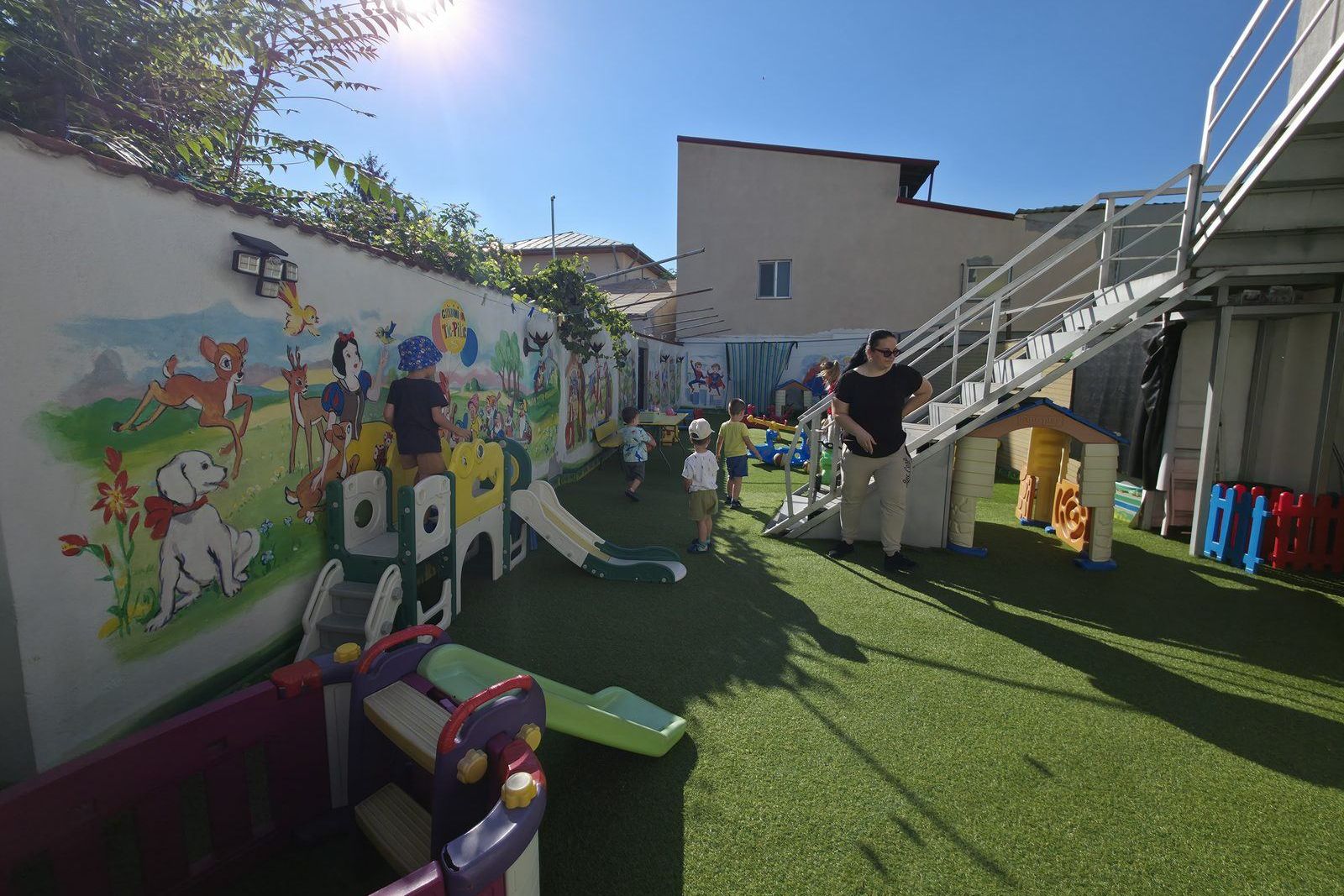 Curtea de joacă a Grădiniței Tic Pitic din Sector 4, cu copii și educatoare